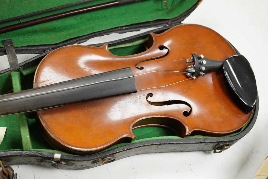 Four cased violins; an early 20th century violin, body 36cm, fitted with a microphone pick up taking a quarter inch jack plug, an early 20th century half size violin, body 32cm, and two student violins. Condition - poor